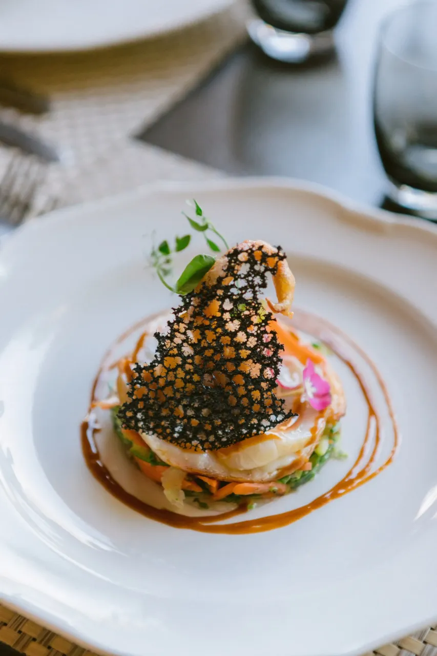 Restaurant situé à Orgon avec un plat gastronomique avec décoration artistique sur assiette blanche.