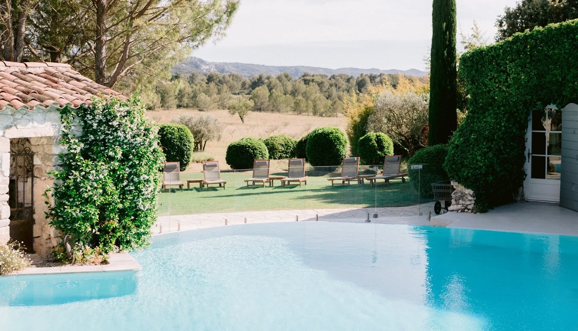 Piscine extérieure devant jardin et chaises longues de notre Mas en Provence